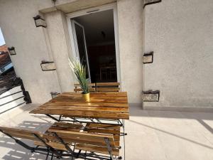 une table et des chaises en bois devant un bâtiment dans l'établissement Magnifique T3 proche Paris & Disneyland, à Ozoir-la-Ferrière