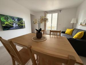 un salon avec une table en bois et un canapé dans l'établissement Magnifique T3 proche Paris & Disneyland, à Ozoir-la-Ferrière 12 autres photos