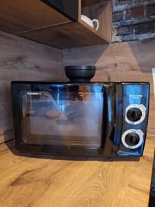 a microwave sitting on top of a kitchen floor at Chez Brigitte et Francis in Perthes