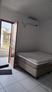 een bed in een kamer met een open deur bij Pousada Casa da Praia in Passo de Torres