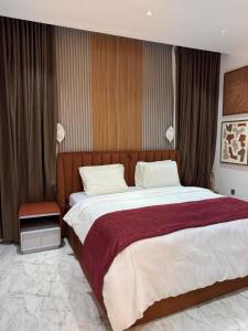 Un dormitorio con una cama grande con una manta roja. en Pavilion Heights, en Lagos