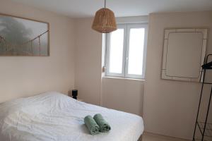a bedroom with a bed with two towels on it at Centre ville - Berthelot in Chamalières