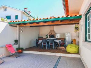 eine Terrasse mit Tisch und Stühlen auf einem Deck in der Unterkunft Casa Gloria in Paço Vedro de Magalhães