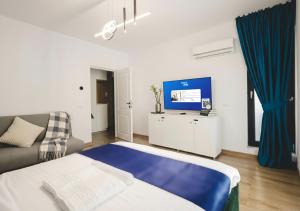 a living room with a bed and a tv at Smart Stay Plaza in Bucharest