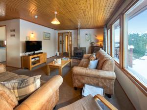 ein Wohnzimmer mit Sofas und einem Flachbildfernseher in der Unterkunft Lorien Cottage in Nethy Bridge