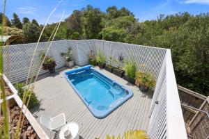 a swimming pool on a deck with plants and a fence at Barbro Warrnambool in Warrnambool