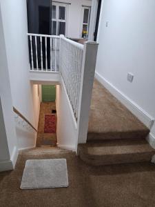 a stairway with a white railing and a rug at home from home 2 bed flat in Kingston upon Thames
