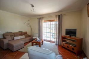ein Wohnzimmer mit Sofa und Fernseher in der Unterkunft Casa Gloria in Paço Vedro de Magalhães