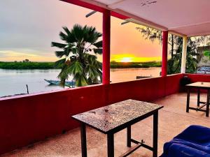 einen Balkon mit einem Tisch und Flussblick in der Unterkunft Auberge Cœur Océan in Joal-Fadiout + 62 Fotos