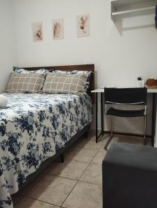 ein Schlafzimmer mit einem Bett, einem Tisch und einem Schreibtisch in der Unterkunft Quarto Hokkaido na Sakura House in Indaiatuba