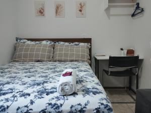 ein Schlafzimmer mit einem Bett mit einer blau-weißen Decke in der Unterkunft Quarto Hokkaido na Sakura House in Indaiatuba