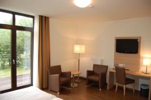 Pokój hotelowy z łóżkiem, biurkiem i krzesłami w obiekcie Hotel Hubertushof w mieście Lingen