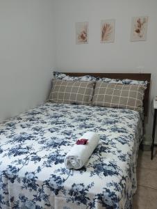 ein Bett mit einem Handtuch darüber in der Unterkunft Quarto Hokkaido na Sakura House in Indaiatuba