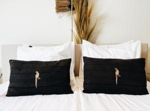 ein Bett mit schwarz-weißen Kissen und einem Vogel darauf in der Unterkunft B&B in woonboerderij vlakbij Lemmer in Rutten + 18 Fotos