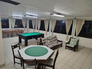 a living room with a ping pong table and chairs at Pousada Nova in Tramandaí