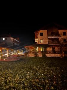 een huis 's nachts met lichten in een veld bij Vâlceaua Zânelor in Stațiunea Climaterică Sâmbăta