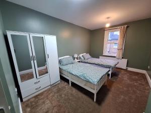 a bedroom with two beds and a mirror at home from home 2 bed flat in Kingston upon Thames