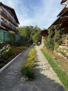 een geplaveid pad tussen twee gebouwen bij Vâlceaua Zânelor in Stațiunea Climaterică Sâmbăta