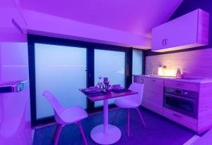 CrisnéeL'Améthyste的厨房配有桌子和2把粉红色的椅子