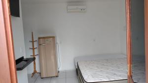 een kamer met een bed en een kleine koelkast bij Pousada Casa da Praia in Passo de Torres
