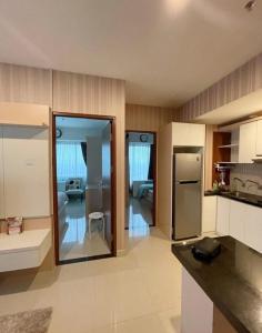 a kitchen with a refrigerator and a living room at Indra Homs in Pabuaran Lima +11 photos