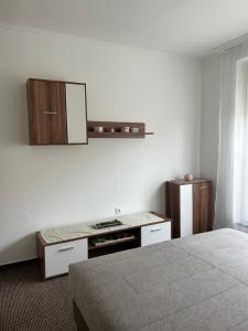 a hotel room with a bed and a stove and cabinets at Mokka Home in Békéscsaba
