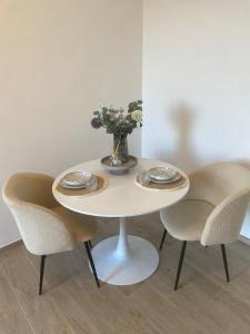 ein weißer Tisch mit Stühlen und einer Vase mit Blumen in der Unterkunft B&B La Fenice in Chieti + 30 Fotos