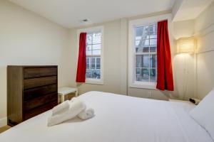 Un dormitorio con una cama blanca y dos ventanas. en Walk to Metro and Dtwn Silver Spring! Sleek Apt, en Silver Spring