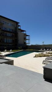 une piscine devant un bâtiment dans l'établissement Increíble Dpto en Costa del Este con vista al mar, à Costa del Este