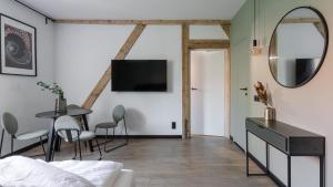 - un salon avec une table et un miroir dans l'établissement Apartamenty Old House Casino Koszarowa 1, à Wrocław