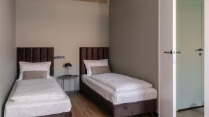 deux lits dans une petite pièce avec dans l'établissement Apartamenty Old House Casino Koszarowa 1, à Wrocław 116 autres photos