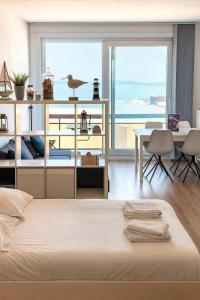a bedroom with a bed with a view of the ocean at Huswell - Beach Studio with Balcony & Sea View in Zeebrugge