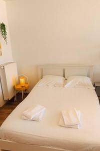 a large white bed with two white pillows on it at Huswell - Beach Studio with Balcony & Sea View in Zeebrugge
