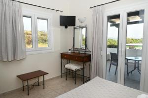 a bedroom with a desk and a mirror and a table at Akrothalassia in Adamantas