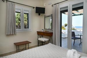 a bedroom with a bed and a desk and a mirror at Akrothalassia in Adamantas