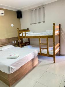 a bedroom with two bunk beds and a television at Parati - Hotel Pousada e Motel in Quatá +12 photos