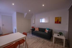 a living room with a couch and a table at Studio central 002B in Saint-Étienne