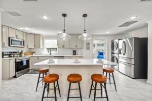 a kitchen with a large white island with bar stools at Full Duplex on Longboat Key, Walk to the Gulf + Cedars East Club Access in Longboat Key