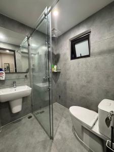 a bathroom with a shower and a toilet and a sink at Studio 3 ByhomeLinh Phố Cổ Hoàn Kiếm in Hanoi +7 photos