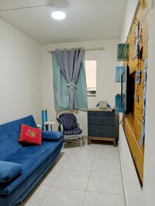 un salon avec un canapé bleu et une chaise dans l'établissement Recanto Aurora de Bombinhas, à Bombinhas 21 autres photos
