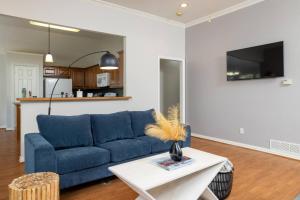 a living room with a blue couch and a table at Near UNT - Downtown Denton - Full Fenced Backyard in Denton