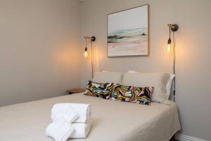 a bedroom with a bed with two lights on the wall at Near UNT - Downtown Denton - Full Fenced Backyard in Denton