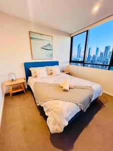 een slaapkamer met een groot bed en een groot raam bij Azure View One-Bed in Gold Coast