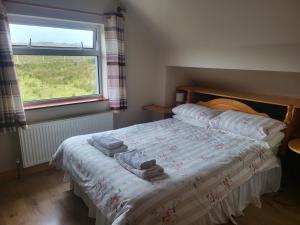 a bedroom with a bed with towels on it at Ard A Mhaoire in Glendorragha