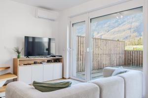 a living room with a couch and a television at Family Apartment Bovec with Free Parking in Bovec