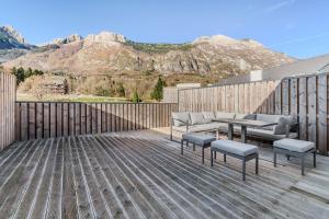a patio with couches and chairs on a wooden deck at Family Apartment Bovec with Free Parking in Bovec