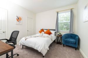 a bedroom with a bed and a blue chair at Fenced Backyard - Walk to Old Town Lewisville in Lewisville