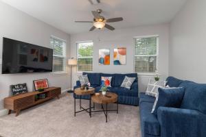 a living room with a blue couch and a tv at Fenced Backyard - Walk to Old Town Lewisville in Lewisville