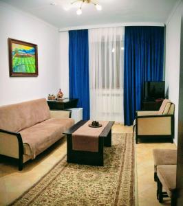 ein Wohnzimmer mit Sofa und Tisch in der Unterkunft Hotel VANGOGH in Zhezdi