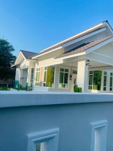 a model of a house behind a fence at Timeless Cottage KB in Kota Bharu
